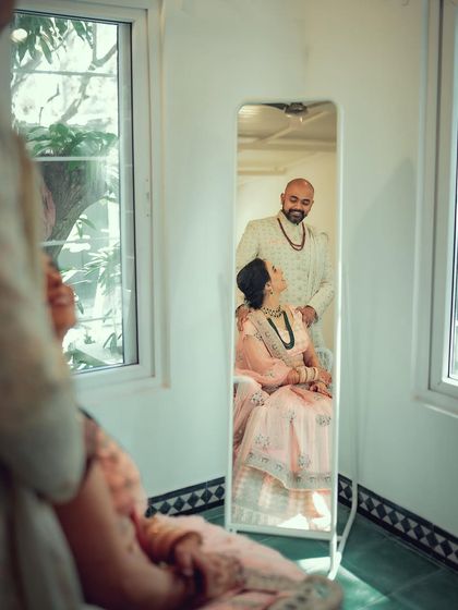 An artistic getting-ready shot, capturing the couple's reflection in a mirror. This adds a layer of storytelling and a unique perspective to the wedding album.