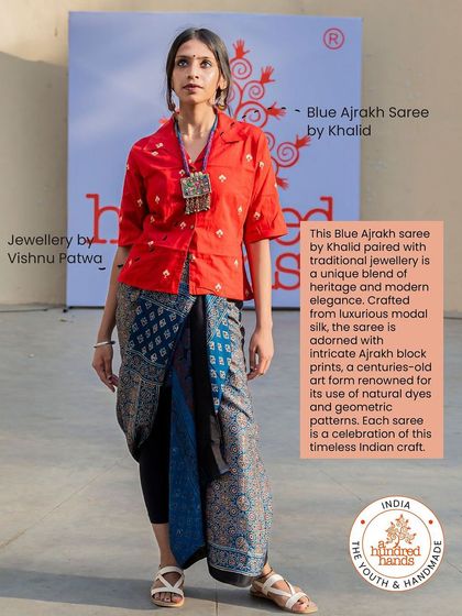 A modern take on tradition. A model wears a blue Ajrakh saree styled unconventionally with a red shirt, paired with traditional jewellery.