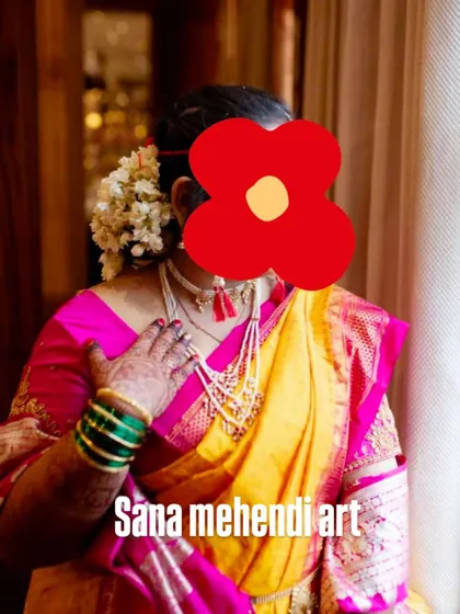 A candid shot of a bride in a traditional Maharashtrian Paithani saree, with her mehendi visible.