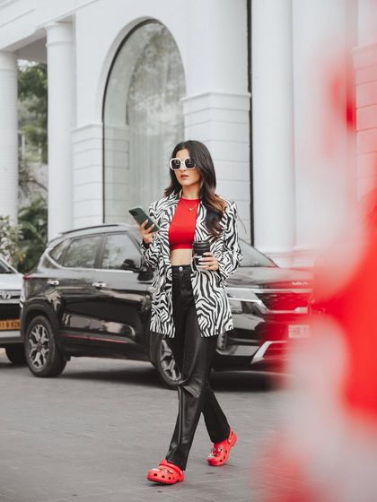 A candid-style street-style shot for Crocs. The model is captured in motion, creating a natural and authentic feel that showcases the shoes in a real-world context.