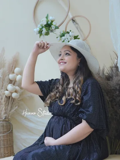 Looking towards a bright future. The addition of a simple sun hat adds a touch of style and grace to this beautiful solo maternity portrait.