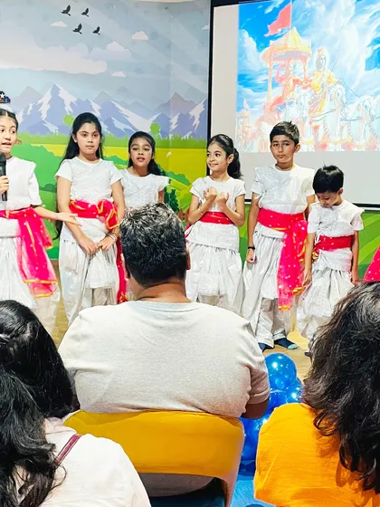 Parents and children watch a stage performance during our Janmashtami event.