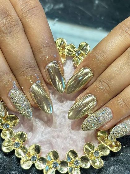 A high-shine, glamorous set combining full gold chrome nails with accent nails covered in gold glitter.
