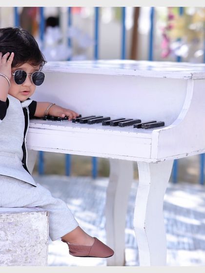 A charming baby shoot featuring our white piano prop. Our studio is equipped with a variety of props suitable for creative and fun photoshoots for kids.