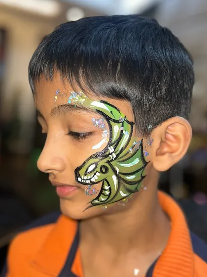 Who said face painting is just for girls? DUH! Learning to paint cool dragons like this one will make you a huge hit with the boys at any event. This design uses bold lines and glitter to really pop.