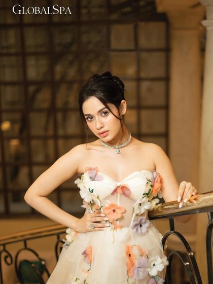 A tighter shot from the staircase set, highlighting the floral details on the gown and the delicate jewelry. The composition is framed to feel personal and engaging.