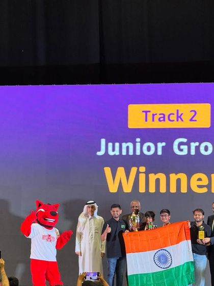 The winners of the Junior Group at the Codeavour International Championship, Team Tech Titans, holding the Indian flag and their trophy high.