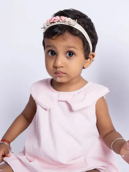 A close-up of the birthday girl with a little bit of frosting on her face. These are the sweet, funny details that make cake smash sessions so memorable.