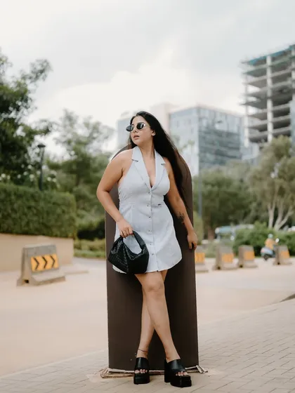 A full-length fashion portrait with the Bangalore cityscape in the background. The model's pose and the urban environment create a stylish and contemporary image.
