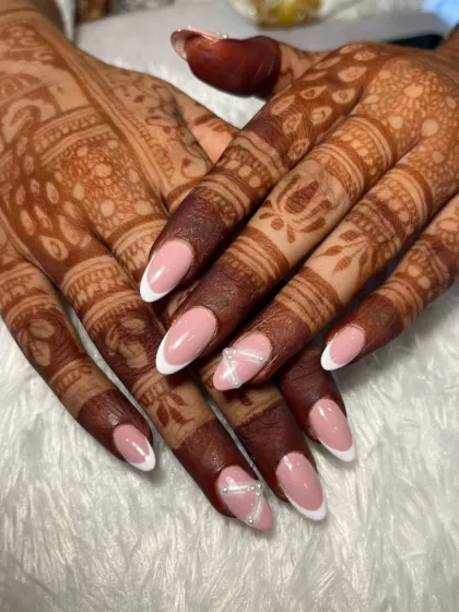A classic and clean look for a bride. This design features a timeless French manicure on almond-shaped nails, with a subtle accent of crisscross silver glitter lines.