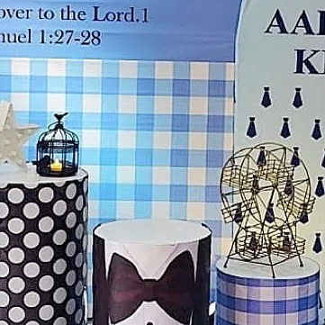 Themed pedestals for a Boss Baby party, featuring polka dots and a tuxedo design. The mini Ferris wheel prop adds a whimsical touch.