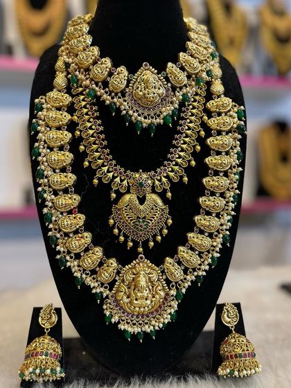 A mango-motif haram set with green bead accents. This is a vibrant and beautiful choice that pairs well with many silk sarees.