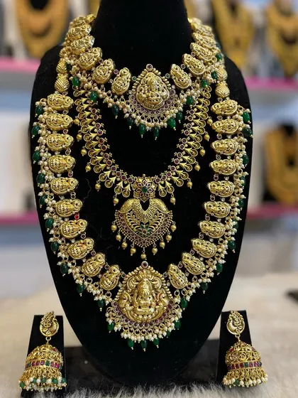 A layered mango-motif haram combined with a floral choker, both featuring green beads and pearl accents.