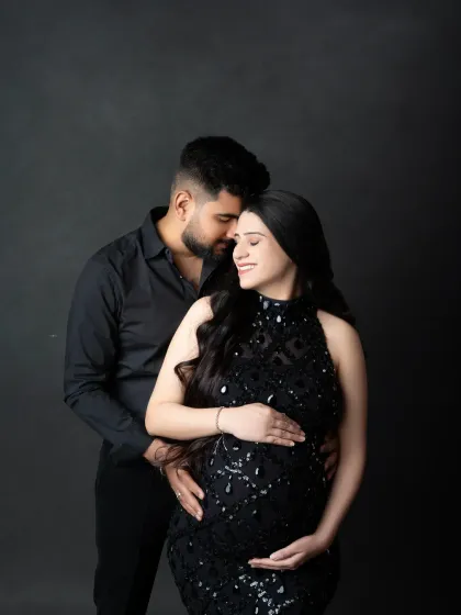 A classic pose for expecting parents. Dressed in elegant black, the couple's connection is the focus of this timeless and sophisticated portrait.