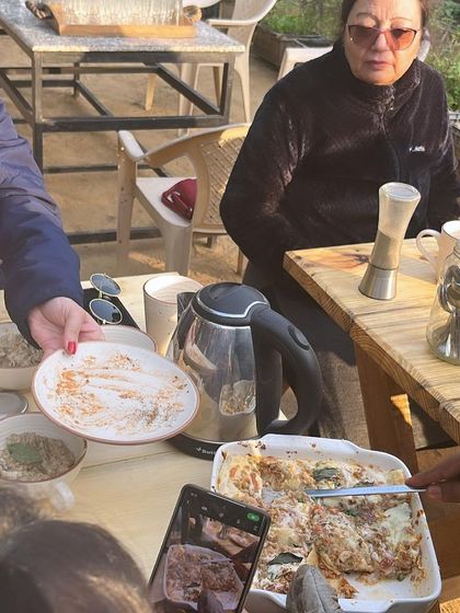 Guests enjoying a meal together at our long community table. Dining at the farm is a shared experience, perfect for making new friends who share a love for nature and good food.