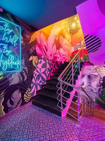 A splash of color at the 'Highdrate' staircase, where vibrant murals and neon lights create a high-energy, photogenic moment.