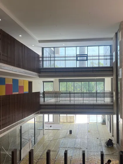 An under-construction view of a multi-story atrium in a new school. This shows the bare structure and scale of the space before final finishes are applied, highlighting the visual connections between floors.