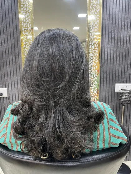 Even without color, the right cut can make a huge difference. For this client, I created defined layers to add shape and volume, styling it with soft curls at the end to enhance the texture.