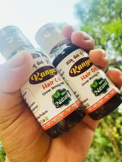 Holding two bottles of my hair growth oil. Many customers buy more than one at a time after experiencing the benefits.