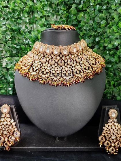 A stunningly detailed and wide kundan choker set, perfect for a bride who wants a bold and traditional look. The set includes the necklace and matching chandelier earrings.