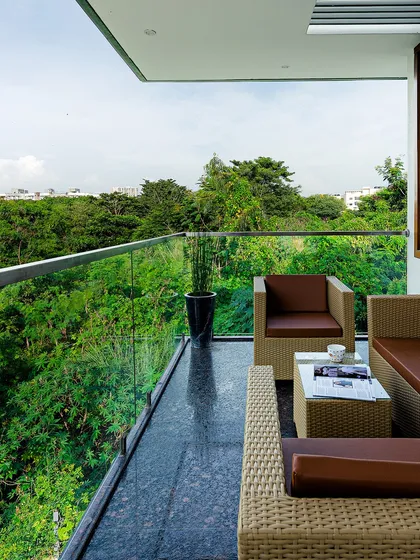 Every bit of open space is an opportunity. This balcony is designed as a private lookout, offering a stunning, uninterrupted view of the surrounding greenery, proving that even compact urban homes can have a connection to nature.