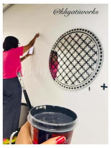 Getting ready to paint. This shot shows my perspective, holding a tub of black paint with the wall design sketched out in the background.