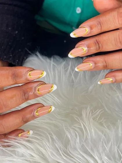 A nude base with a white and gold double French outline. This is a very sophisticated and modern design.