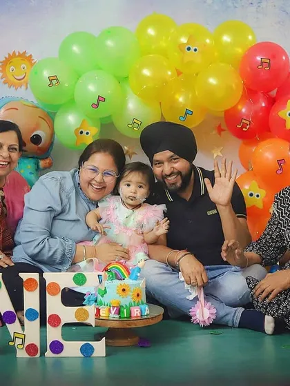 A big, happy family celebrating a Cocomelon-themed first birthday! It's wonderful when grandparents and extended family can join the photoshoot.