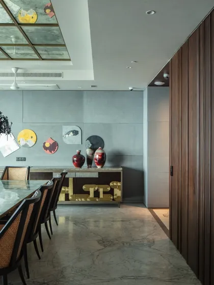 The dining room at 'The 42, Kolkata', featuring a custom sideboard with 'Thathera' work, a traditional hammered metal craft. This piece is a prime example of how we collaborate with artisans to keep heritage crafts alive.