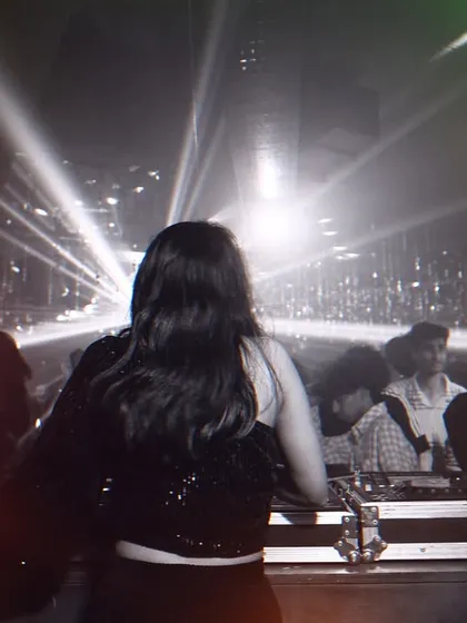 Facing the light. A powerful shot from behind the decks, with stage lights creating a starburst effect around me.