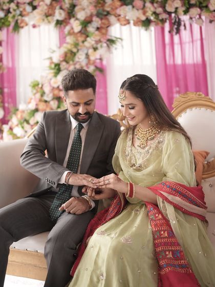 A sweet moment during the ring ceremony. Her makeup is soft and traditional, with a focus on enhancing her natural beauty.