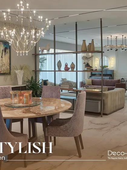 A closer look at this stylish haven, where modern aesthetics meet comfortable seating. The room features a mix of plush sofas, unique accent chairs, and lush greenery, creating a perfect setting for gatherings.