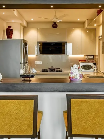 This C-shaped acrylic kitchen includes a breakfast counter, seamlessly connecting the kitchen to the living area. It's a perfect example of how we design spaces that are both functional and social.