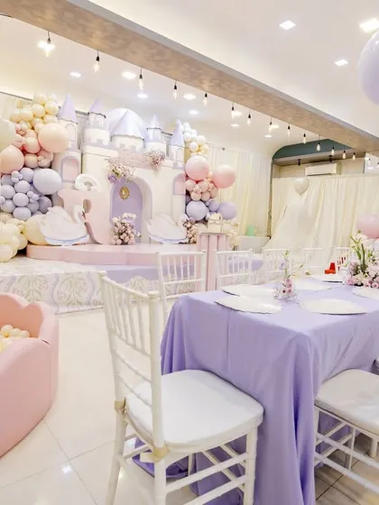The full party space for Radha's birthday, showing the grand castle stage, the elegant dining area, and a perfectly coordinated pink ball pit for the little ones.