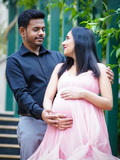 An intimate moment between expecting parents during an outdoor maternity shoot. The soft light and natural setting in Bengaluru perfectly frame their loving anticipation.