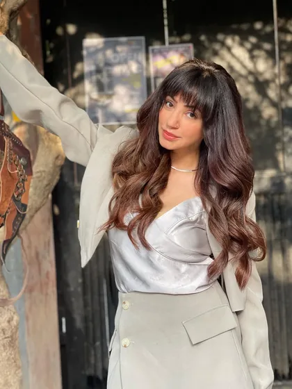 I love a good retro-inspired look. This haircut features heavy bangs and soft layers, styled with full-bodied waves for a fun, vintage feel that's reminiscent of classic comic book characters but with a modern twist.