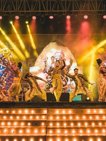 A powerful sangeet performance with a Ganesha-themed LED backdrop. The choreography is energetic and synchronized with the entire dance troupe, creating a visually stunning act.