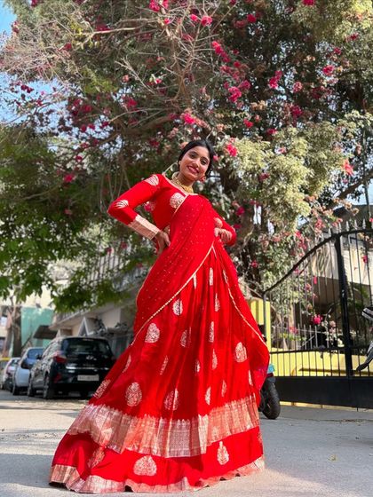 Another angle of the stunning red langa voni, showing how it stands out against a natural background. It’s a perfect outfit for an outdoor event or a photoshoot.