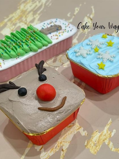 My mini loaf cakes get a festive makeover for Christmas. Here you can see them decorated as a reindeer, a Christmas tree, and a snowy sky, making them a cute and delicious holiday treat.