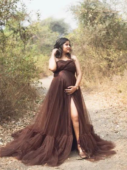 Taking the glamour outdoors. This beautiful mom-to-be in a flowing brown gown looks like a woodland goddess, perfectly at home in the rustic, natural setting of a park shoot.