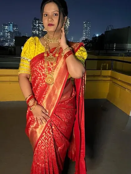 This photo captures the complete traditional look, from the perfectly draped saree to the confident pose. The bright yellow blouse contrasts beautifully with the red saree.