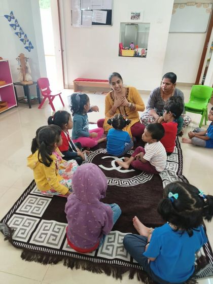 A beautiful moment of community and learning. A guide sits with a group of children for a circle time lesson, a time for stories, songs, and shared experiences that build our classroom family.