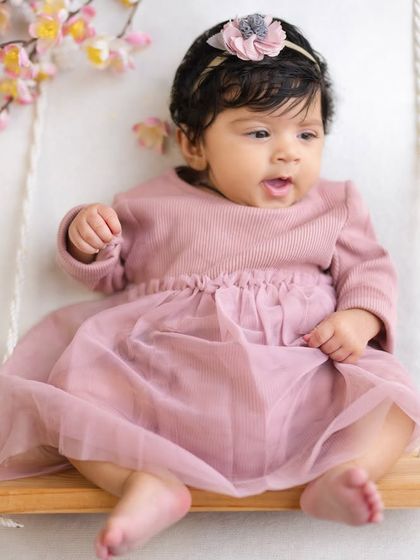 A curious expression from a three-month-old baby on her floral swing. I love capturing these moments as their little personalities start to shine through.