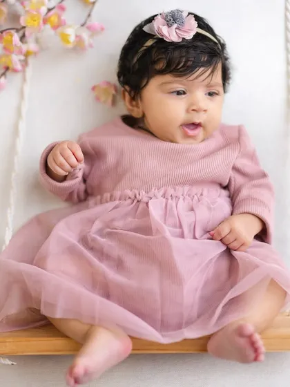 A curious expression from a three-month-old baby on her floral swing. I love capturing these moments as their little personalities start to shine through.