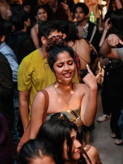 A candid shot of someone dancing with fairy lights, adding to the magical atmosphere of the night.