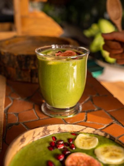 A glass of our signature green smoothie, a cornerstone of the diet I recommend. Packed with leafy greens and fruits, this simple daily habit provides a powerful dose of vitamins, minerals, and antioxidants to kickstart your day and your health.