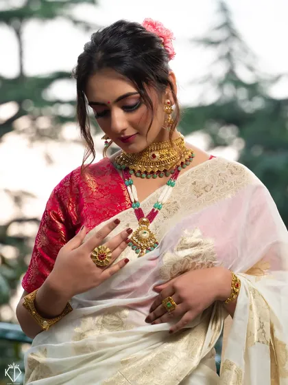 A beautiful portrait showcasing the complete traditional look, with a focus on the layered gold necklaces.
