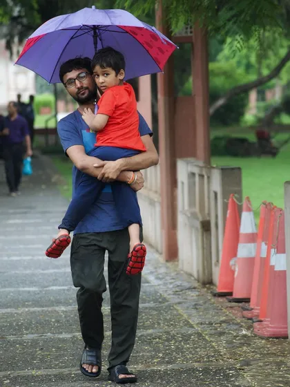 A father carries his son on a rainy day. This is the kind of in-between moment I love to capture for families. It’s an unposed, candid family portrait that tells a story of care and connection, rain or shine.