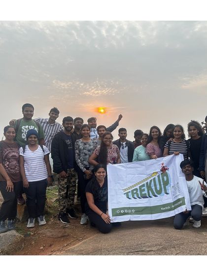 Our group posing with the Trekup banner during a sunrise trek to Huthridurga.