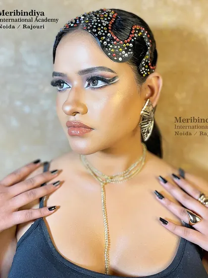 This creative look combines a bold, graphic winged eyeliner with a bejeweled, sculpted hairstyle, showcasing the avant-garde techniques taught in our advanced courses.